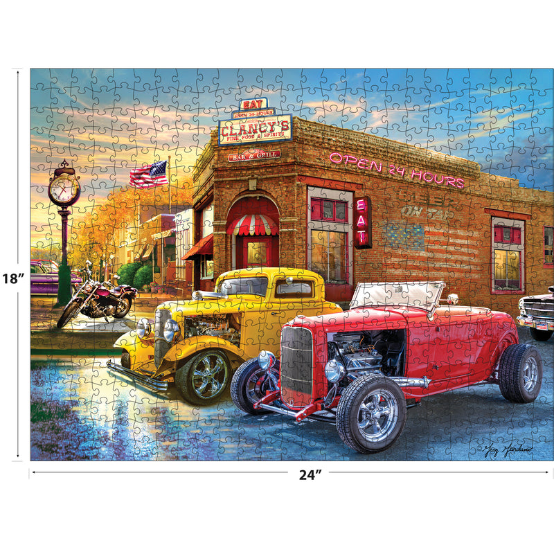 A completed RoseArt - American Nostalgia - American Grill - 500 Piece Jigsaw Puzzle depicting classic cars and a motorcycle parked in front of a diner, with the dimensions noted as 18 inches by 24 inches.