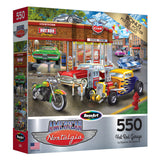 Puzzle box labeled "RoseArt - American Nostalgia - Hot Rod Garage - 550 Piece Jigsaw Puzzle" featuring vintage cars, motorcycles, and a classic gas station illustration.