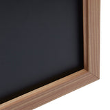 A close-up view of the corner of a Board Dudes Chalk Board - Wood Frame 35x23 INCH, showing the dark black surface and light brown wood edging.