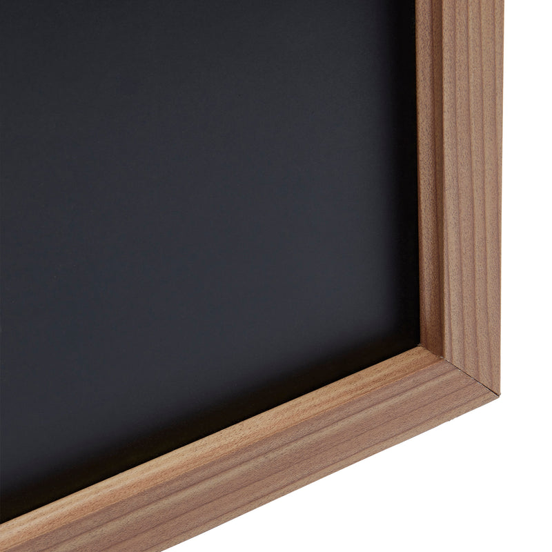 A close-up view of the corner of a Board Dudes Chalk Board - Wood Frame 35x23 INCH, showing the dark black surface and light brown wood edging.