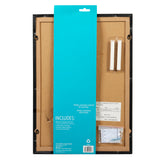 Back view of a mounted Board Dudes Magnetic Chalk Board with Easel 11 x 15.5 inches: Versatile Organization and Style kit featuring a wooden frame, instruction label, and the included hanging hardware in a plastic bag.