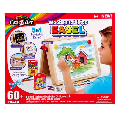 Cra-Z-Art 16 x 12 inch Wooden Tabletop Easel: 5-in-1 Creativity Station with Complete Art Supplies! with a child drawing on it. Features 60+ pieces, a 5-in-1 portable design, and is suitable for ages 6+. Includes paint, chalk, markers, paper, and more.