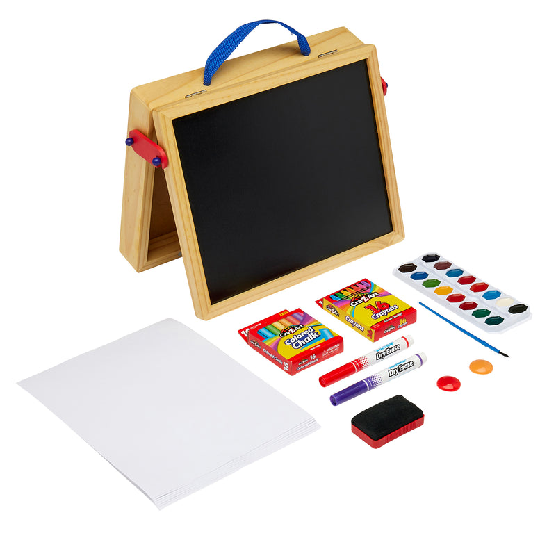 A Cra-Z-Art 16 x 12 inch Wooden Tabletop Easel: 5-in-1 Creativity Station with Complete Art Supplies! stands surrounded by art supplies, including Crayola markers, crayons, a glue stick, watercolor paints, paintbrush, white paper sheets, and an eraser sponge.