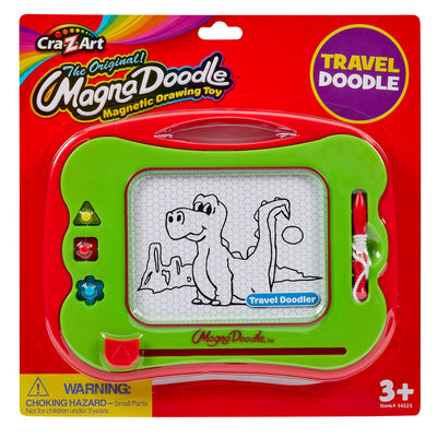 Travel Magna Doodle in green packaging with a cartoon dinosaur drawing on the screen. Box labeled "3+." Includes a pen and shaped stampers. Warning about small parts hazard.