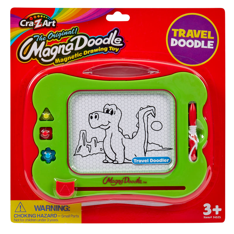 Travel Magna Doodle in green packaging with a cartoon dinosaur drawing on the screen. Box labeled "3+." Includes a pen and shaped stampers. Warning about small parts hazard.