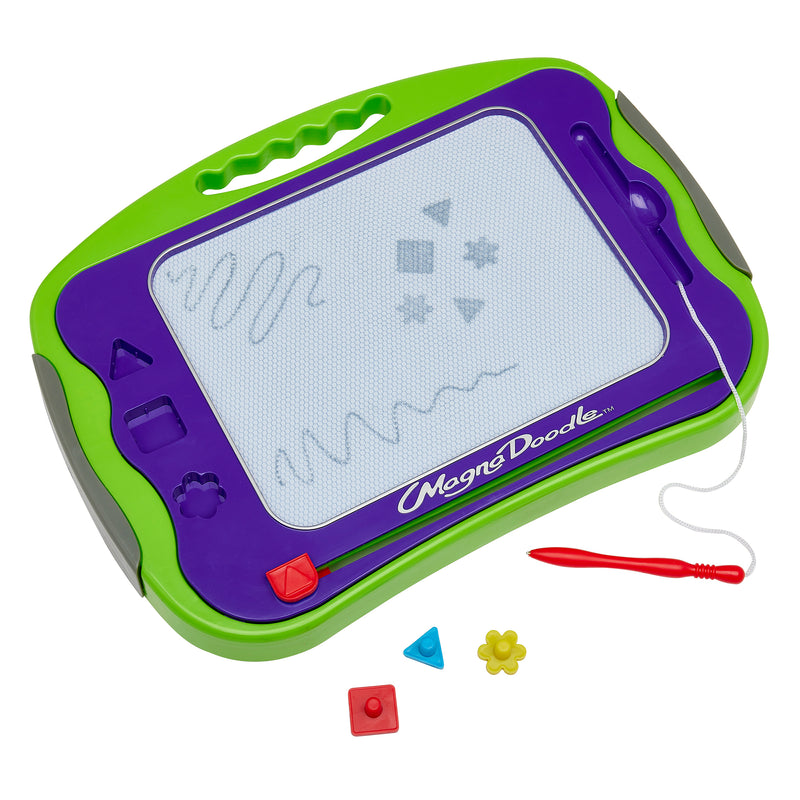 A green and purple Original Magna Doodle drawing board with various squiggles and shapes drawn on the screen, including a stylus and three magnetic stampers in red, blue, and yellow beside it.