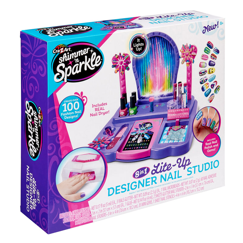 A box of the Shimmer 'n Sparkle 8 In 1 Lite-up Designer Nail Studio, showing various tools for nail design, including fashion nail designs and a real nail dryer.