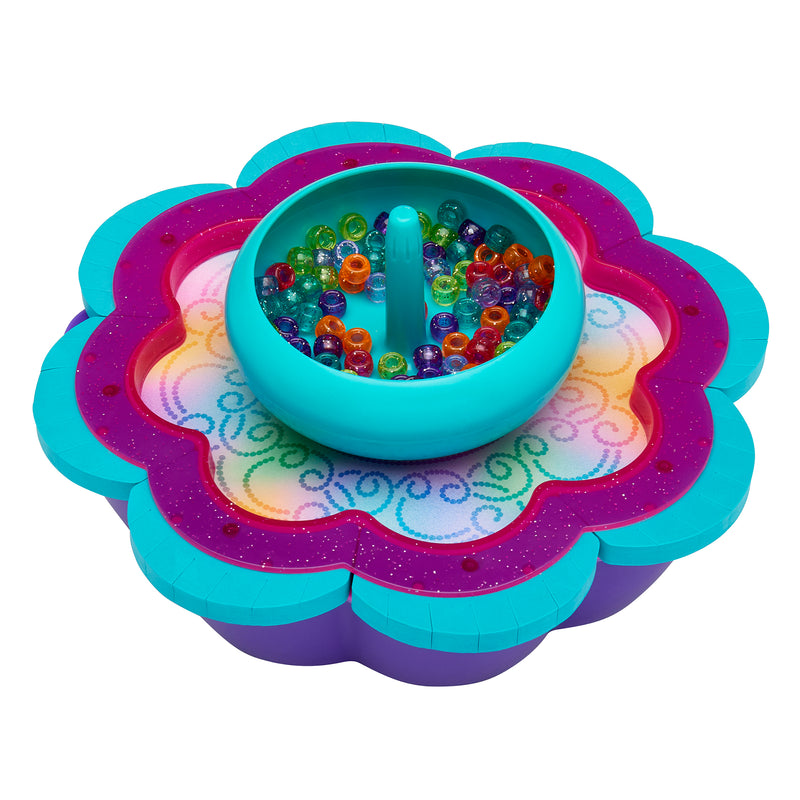Colorful Shimmer 'n Sparkle 2 in 1 Spin & Bead Bracelet Studio with a circular teal basin holding multicolored beads, set in a flower-shaped, multicolored base.