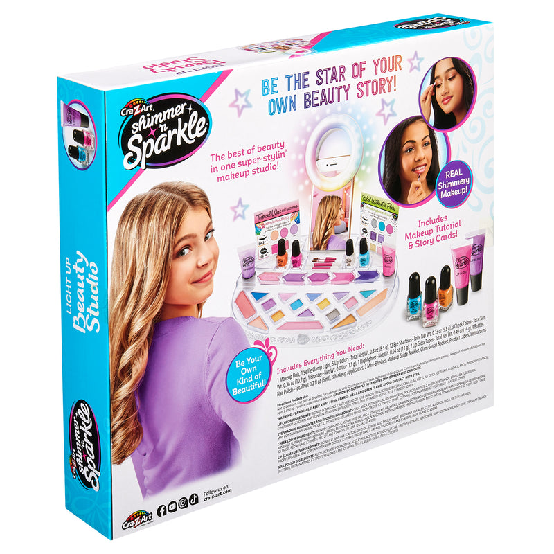Back of the "Shimmer 'n Sparkle Light Up Beauty Studio" makeup kit packaging, featuring product contents, images of young girls, and promotional text highlighting makeup tutorial and story contents.