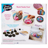 A Cra-Z-Art Shimmer 'n Sparkle Metallic Mania Rock Art kit showing painted rocks, examples of crafted designs, and included supplies like paintbrushes, paints, and rocks.