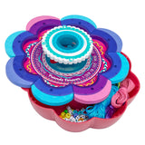 Shimmer 'n Sparkle 6 in 1 Friendship Bracelet Studio containing colorful threads, strings, letter beads, and other small beads, with a doughnut-shaped tool at the center.