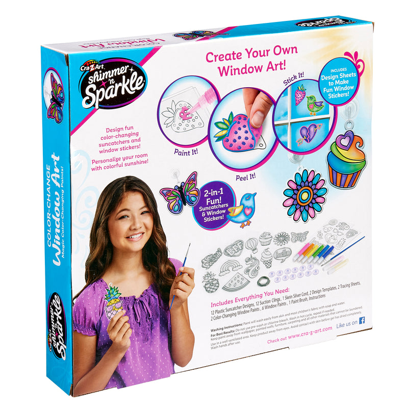 Box of "Shimmer 'n Sparkle Color Change Window Art" craft kit. The packaging features a smiling girl holding a completed design. The kit includes paints, stickers, design sheets, and instructions for making window art.