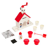 Image of a Snoopy Snow Cone Maker with accessories including three cups, two scoopers, flavored syrup, a packet, and two paper cups. The machine resembles Snoopy's doghouse with Snoopy on the roof.