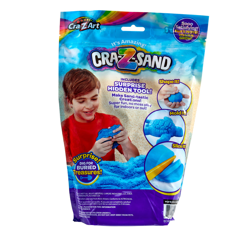 A package of Cra-Z Sand Blue Blast 3lb Bag featuring a child playing with blue sand. The package highlights "includes surprise hidden tool," "shape it," "mold it," and shows a hidden tool being uncovered.