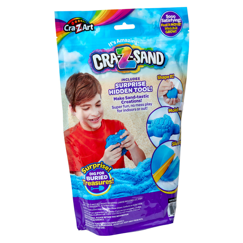 A package showing Cra-Z Sand Blue Blast 3lb Bag. The package includes blue sand, a hidden tool, and promotes various shapes and molds. The front features a young person playing with the sand.