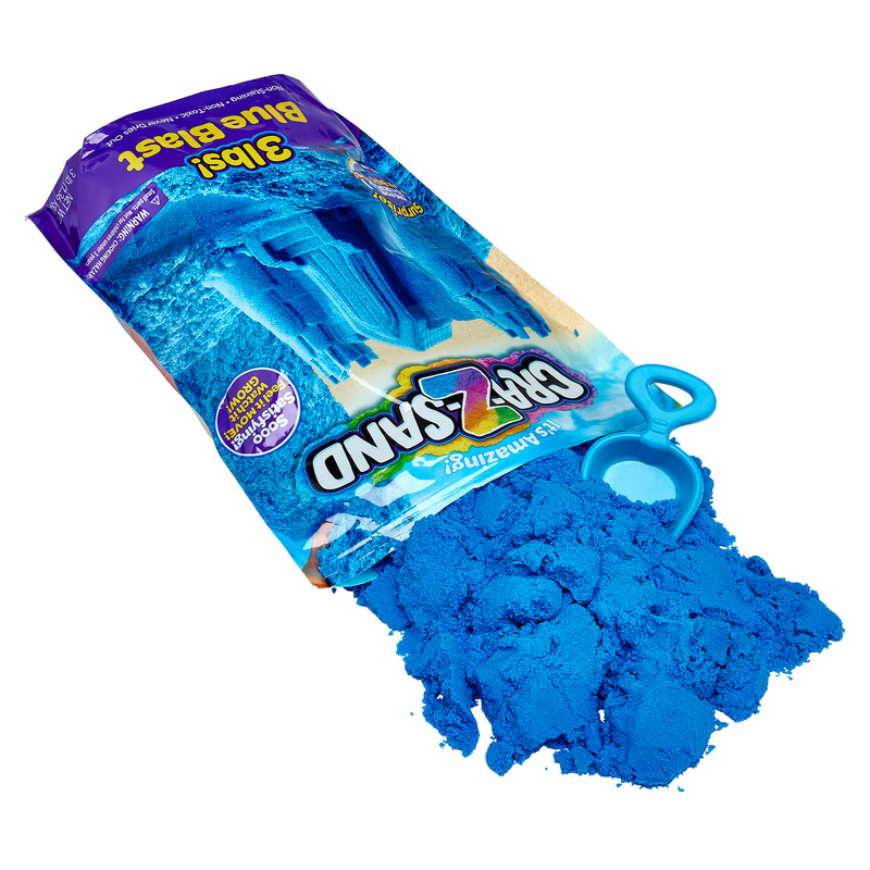 A bag of Cra-Z Sand Blue Blast 3lb Bag is open, with sand spilling out onto a surface. A small, blue plastic tool is visible next to the sand. The bag is labeled "Cra-Z-Sand" and "3 lbs! Blue Blast.