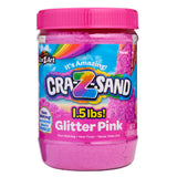 A 1.5 lb tub of Cra-Z-Sand Pink Glitter Sand. The packaging describes it as non-staining, non-toxic, and never drying out, suitable for ages 4+. The tub has a pink lid and colorful label.