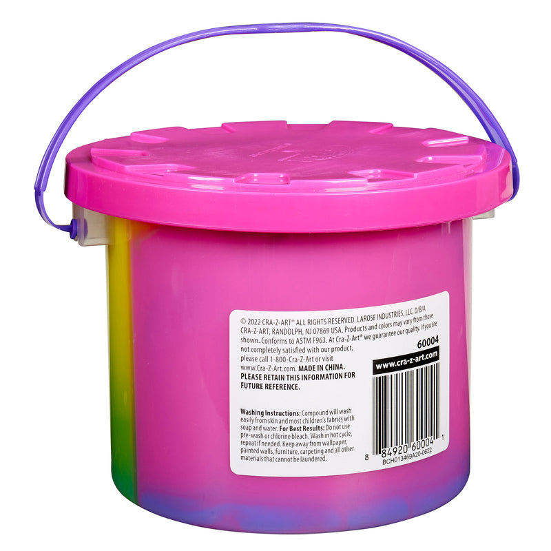 A pink plastic container with a purple handle and lid, containing art supplies. The product label includes usage warnings and the website address for more information is Cra-Z-Slimy Bucket TRICOLOR RAINBOW 48 OZ.