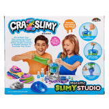 The image shows a Cra-Z-Slimy Metallic Slimy Studio kit, featuring children making slime with various ingredients, and colorful slime examples, packaged in a colorful box.