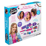 Box of "Shimmer 'n Sparkle BRAID & WRAP HAIR DESIGNER" showing tools and accessories for braiding and decorating hair, including beads, threads, and styling tools, with images of styled hair.