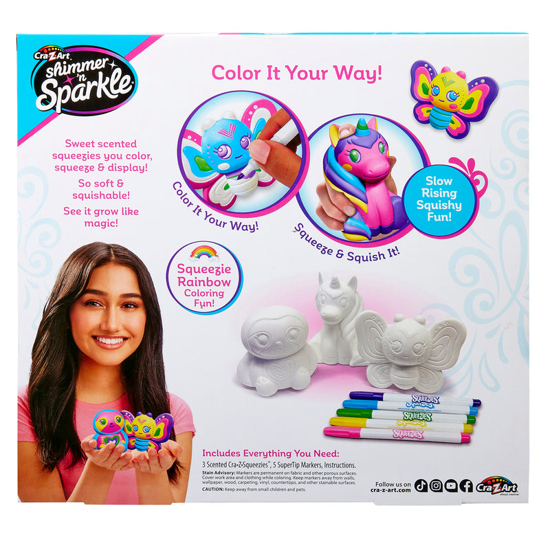 Packaging for "Shimmer 'n Sparkle Cra-Z-Squeezies Color Your Own Squeezie Fun" featuring a girl holding a colored squishy toy. Box includes uncolored toys, markers, and instructions for creating slow rising squishy toys.