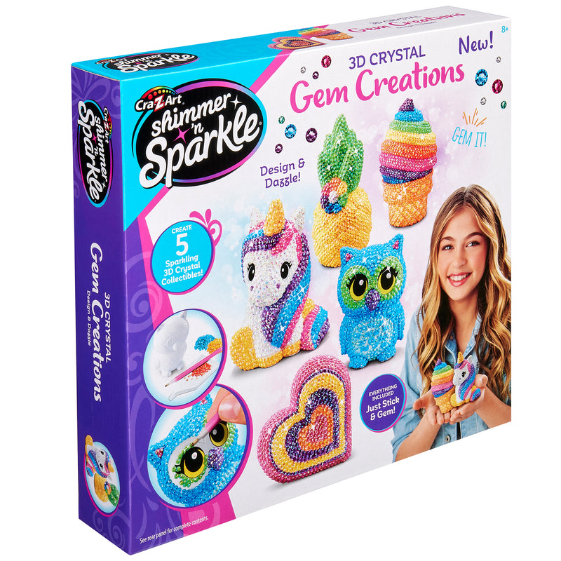 The image shows a Shimmer 'n Sparkle 3 D Crystal Gem Creations kit. The packaging features colorful gem-covered figures, including a unicorn, owl, and ice cream cone, with tools for crafting.