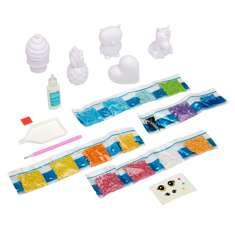 A Shimmer 'n Sparkle 3D Crystal Gem Creations set with various tools, colorful diamond beads, cartoon figurines, adhesive accessories, and decorative items including a heart and animal shapes.