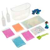 Image of The Little Mermaid Sqand Castle Playset. Includes a transparent plastic container, two squeeze bottles, four packets of colored sand, stickers, a green scoop tool, and plastic decorations shaped like a mermaid and sea creatures.