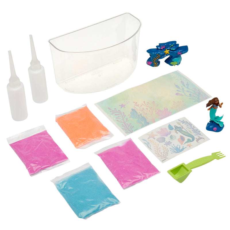 Image of The Little Mermaid Sqand Castle Playset. Includes a transparent plastic container, two squeeze bottles, four packets of colored sand, stickers, a green scoop tool, and plastic decorations shaped like a mermaid and sea creatures.