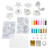 The Little Mermaid 2 in 1 Window Set including color-in animal and sea creature templates, glitter glue tubes, small containers, glitter packets, wire, and blank sheets of white paper arranged on a white background.