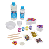 Cra-Z-Slimy DIY Super Slimy Shoppe make-your-own slime kit out of package with clear slime glue, activator, pink, blue, yellow and purple colors, confetti, beads, and slime-making supplies.