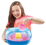 A girl in a pink shirt making pink cotton candy using The Real Cotton Candy Maker.