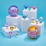 Disney Crystal Surprise Color Change Ball toys displayed on white platforms alongside two larger unopened packages.