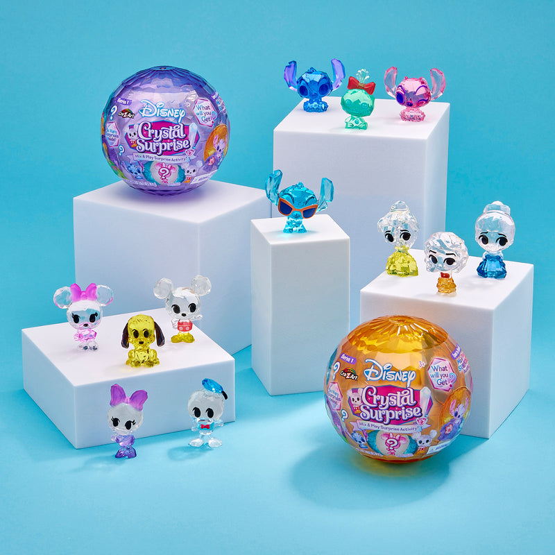 Disney Crystal Surprise Color Change Ball toys displayed on white platforms alongside two larger unopened packages.