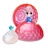 Uncover the enchanting Disney Crystal Surprise Color Change Ball: a toy figure housed within a pink, gemstone-shaped container, reminiscent of a Disney princess with a blue top and translucent hair. The set also features a white accessory adorned with a small blue figurine, enhancing its magical allure.
