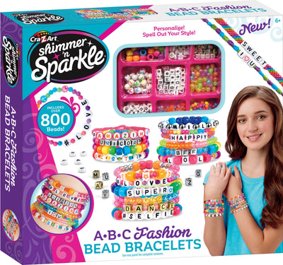 Box containing Shimmer 'N Sparkle ABC Bead Bracelets with over 800 beads. The image shows colorful bracelets and materials for creating personalized bead jewelry, along with a smiling girl.
